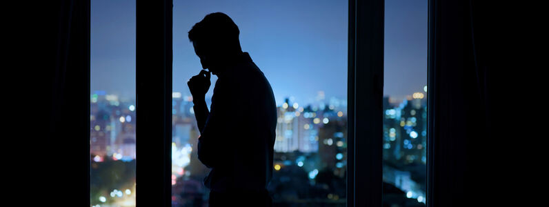 Worried,Asian,Young,Businessman,Is,Standing,Near,Windows,While,Working